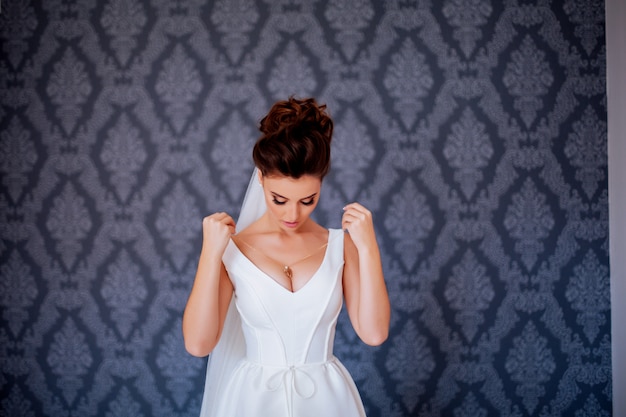 Beautiful bride posing in her wedding dress indoors