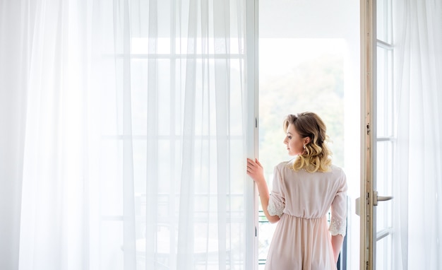 The beautiful  bride stands near balcony