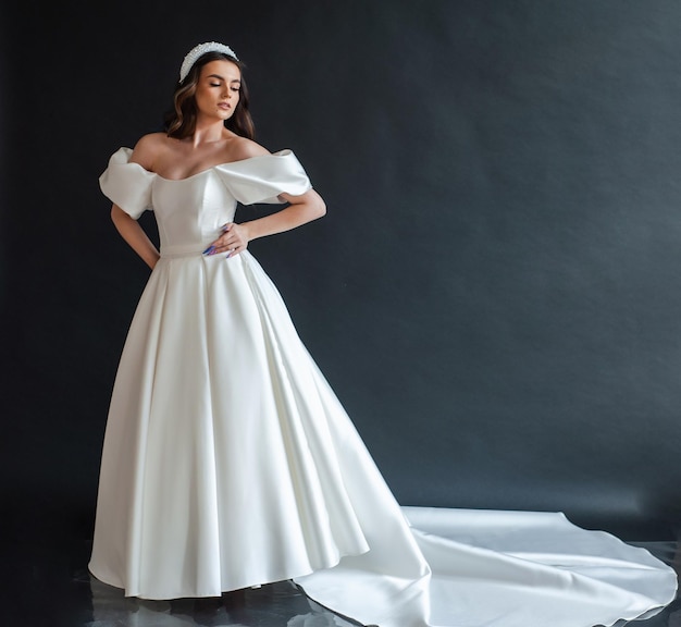 Beautiful bride wearing wedding dress in dark interior