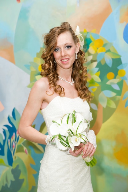 Beautiful bride in a white dress with a bouquet of calla lilies