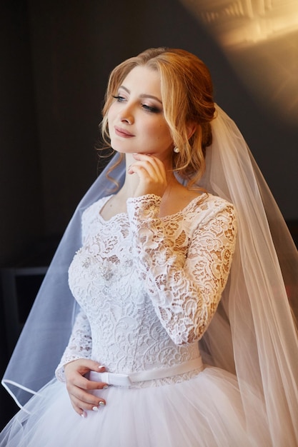 Beautiful bride in white wedding dress on wedding day. A woman is waiting for her fiancÃÂÃÂ© before the wedding ceremony. Girl with a veil on her head