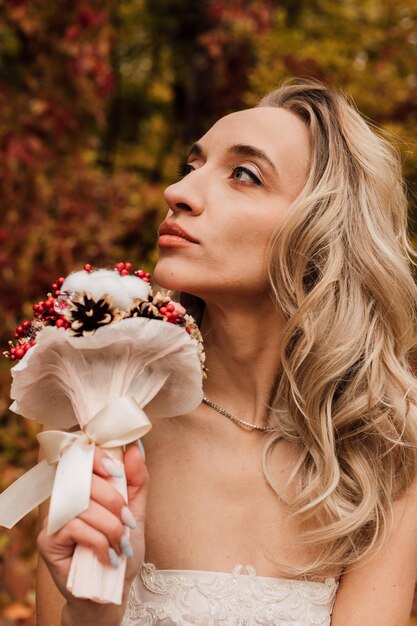 Photo beautiful bride with a bouquet in her hands wedding in autumn in the forest