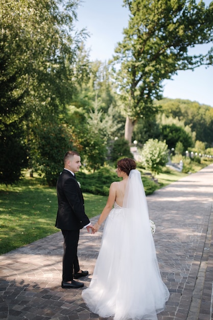 Beautiful bride with her handsome groom walking outside on theri wedding day.