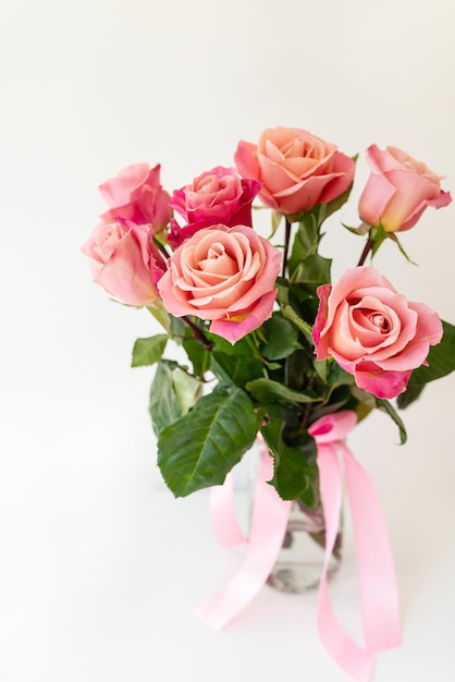 Beautiful bright pinkred roses flowers in a vase side view vertical photo Flowers for the holiday