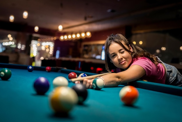 Beautiful brunette about to shoot snooker