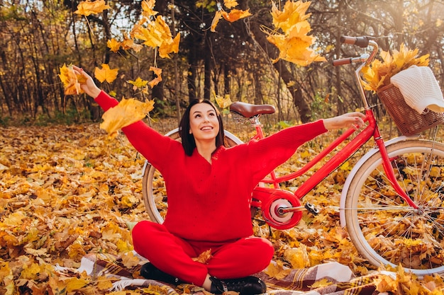 Beautiful brunette in the autumn forest with a bicycle