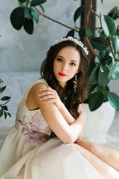 Beautiful brunette bride hugs herself by the shoulders