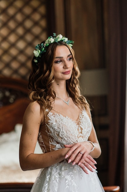 Beautiful brunette bride in a luxurious wedding dress in rich vintage interior