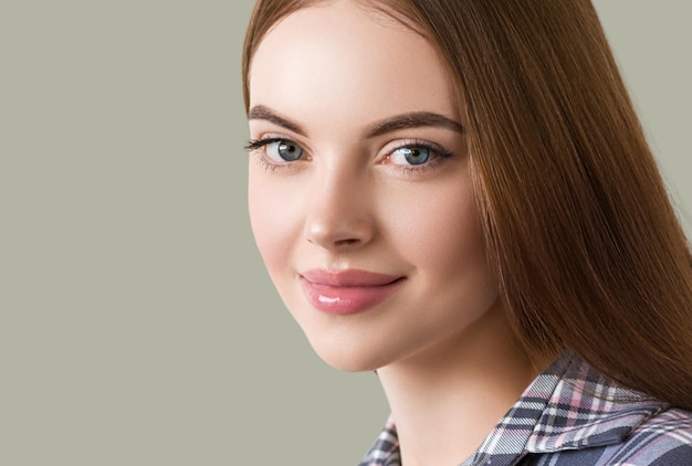 Beautiful brunette in check dress natural portrait. Color background. Green