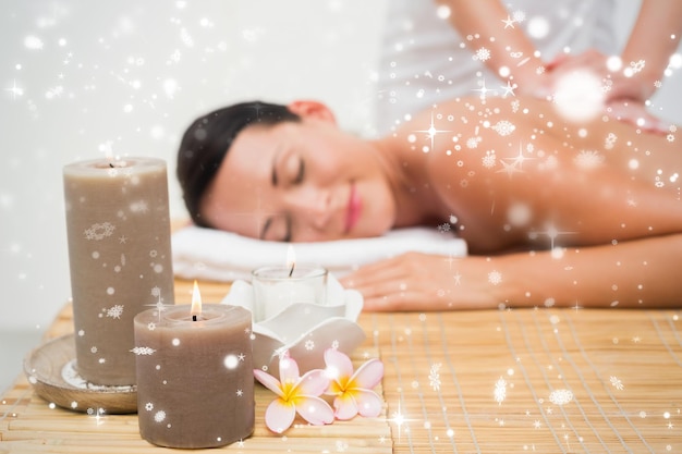 Beautiful brunette enjoying a back massage  against snow falling