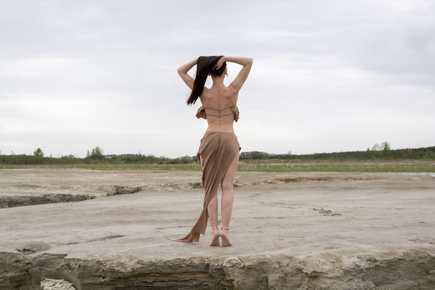 Beautiful brunette girl in an amazon costume in the desert