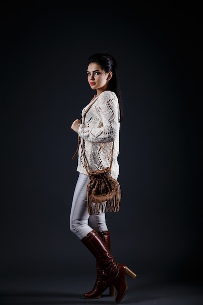 Beautiful brunette girl in beige sweater and brown bag