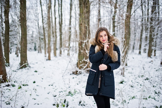 Beautiful brunette girl in winter warm clothing. Model on winter jacket.