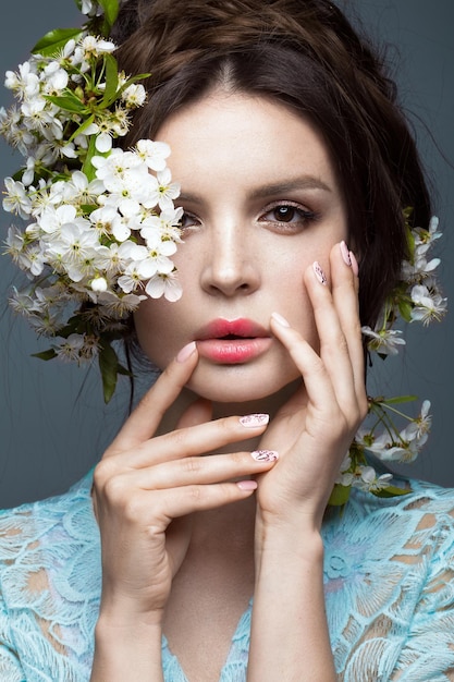 Beautiful brunette girl  with a gentle romantic makeup pink lips and flowers