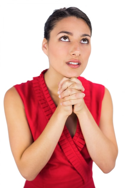 Beautiful brunette in red dress praying