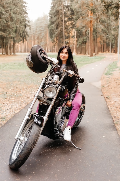 The beautiful brunette riding a motorcycle in the park