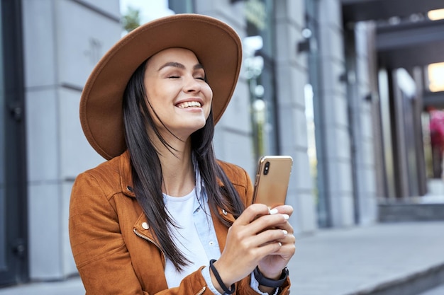 Beautiful brunette with closed eyes using smartphone