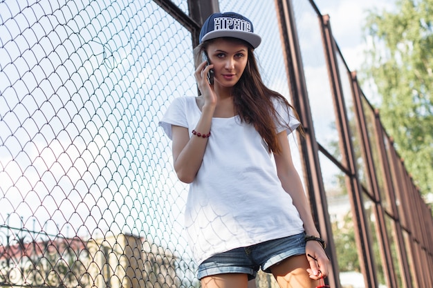 Beautiful brunette woman closeup portrait speaking the phone outdoor in summer on the street