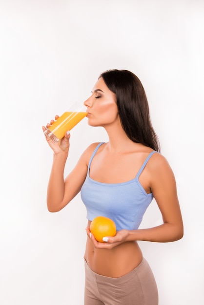 Beautiful brunette woman drinking orange juice