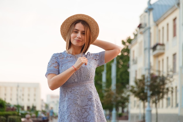 Beautiful brunette young woman wearing dress and walking on the street.