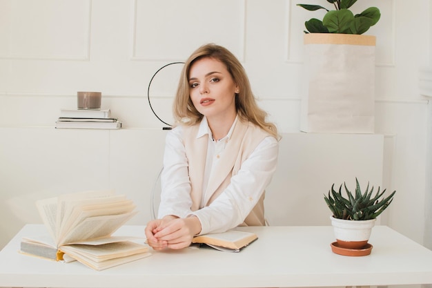 Beautiful business lady sitting at the table with a book