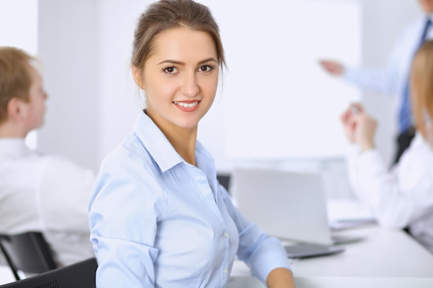 Beautiful business woman on the background of business people during meeting