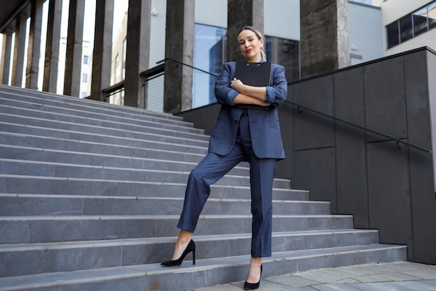 Beautiful business woman in elegant formal suit holding a clipboard folder in her hands