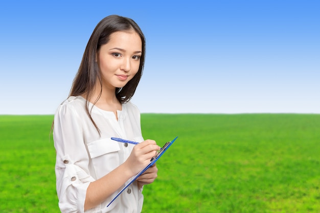 Beautiful business woman taking notes on her clipboard