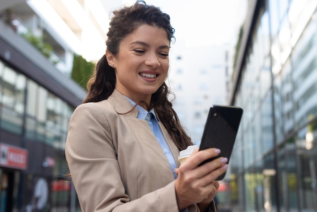 Beautiful business woman using phone outdoors