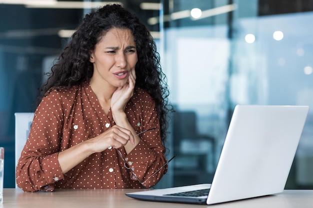 Beautiful business woman working inside office building patient has severe toothache worker uses