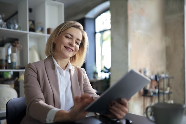 Beautiful business woman on the workplace using a digital tablet.