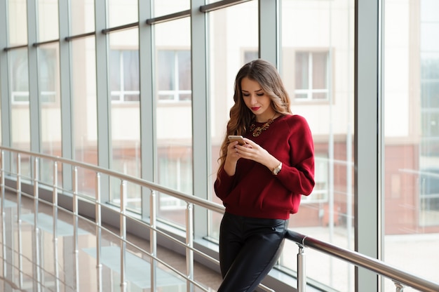 Beautiful business woman writing sms on a mobile phone.