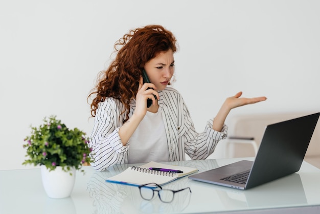 Beautiful businesswoman working on projects Young businesswoman talking to the phone at office desk