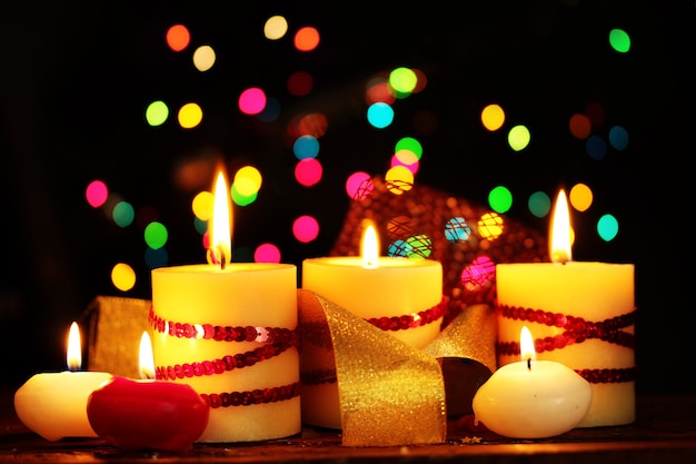 Beautiful candles on wooden table on bright background