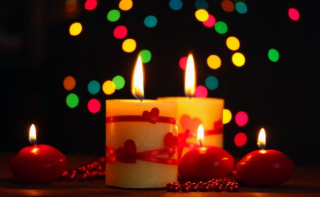 Beautiful candles on wooden table on bright background