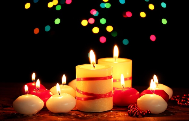 Beautiful candles on wooden table on bright background