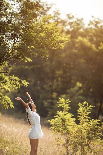 Beautiful carefree woman in fields being happy outdoors