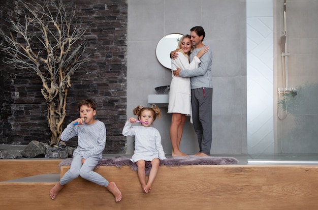 Beautiful caucasian family washing in morning and brushing teeth