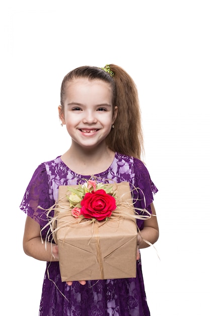 Beautiful caucasian girl in purple lace dress holding a box with a gift decorated with flowers. Shooting in studio on isolated white background