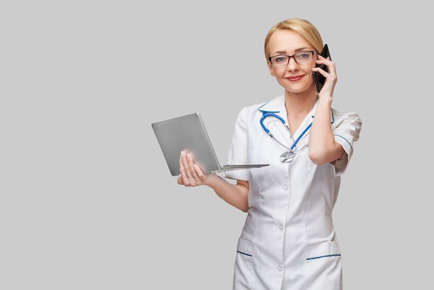 Beautiful Caucasian woman doctor or nurse holding a laptop pc computer.