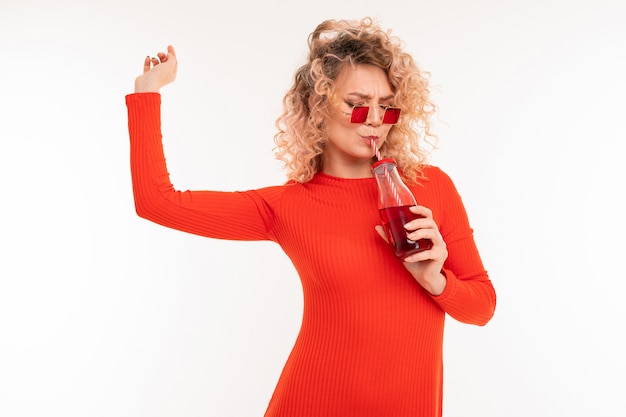 Beautiful caucasian woman drinks red juice