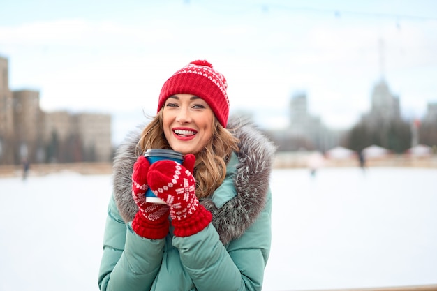 Beautiful caucasian woman standing near ice skate rink Winter holiday