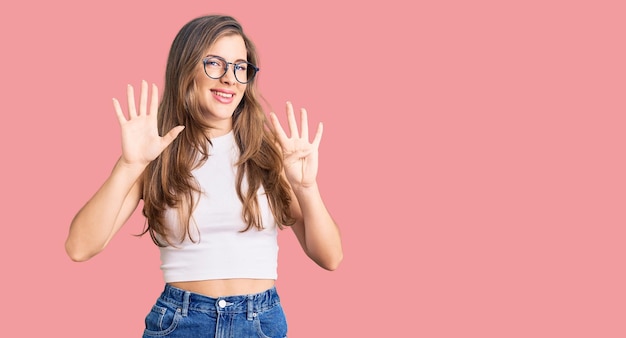 Beautiful caucasian young woman wearing casual clothes and glasses showing and pointing up with fingers number eight while smiling confident and happy.