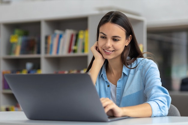 Beautiful caucasian young woman working online uses a laptop. Online communication, distance teaching concept