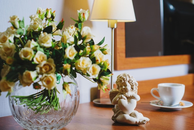 Beautiful ceramic figurine of an angel on the table on the background of the hotel room