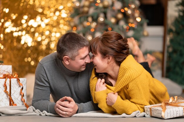 A beautiful cheerful couple greets the Christmas holidays in a cozy home atmosphere.