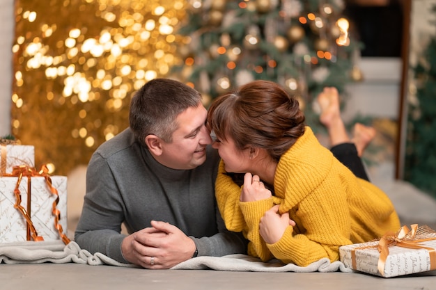 A beautiful cheerful couple greets the Christmas holidays in a cozy home atmosphere