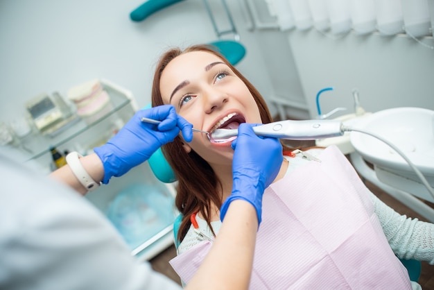 Beautiful, cheerful girl in the dentist's chair. Dental treatment. Dental clinic