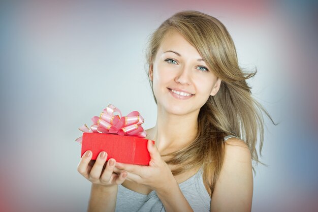 Beautiful cheerful girl with a gift