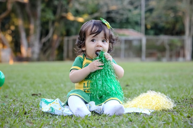 Beautiful child of the Brazilian soccer team in a park dressed up in green and yellow